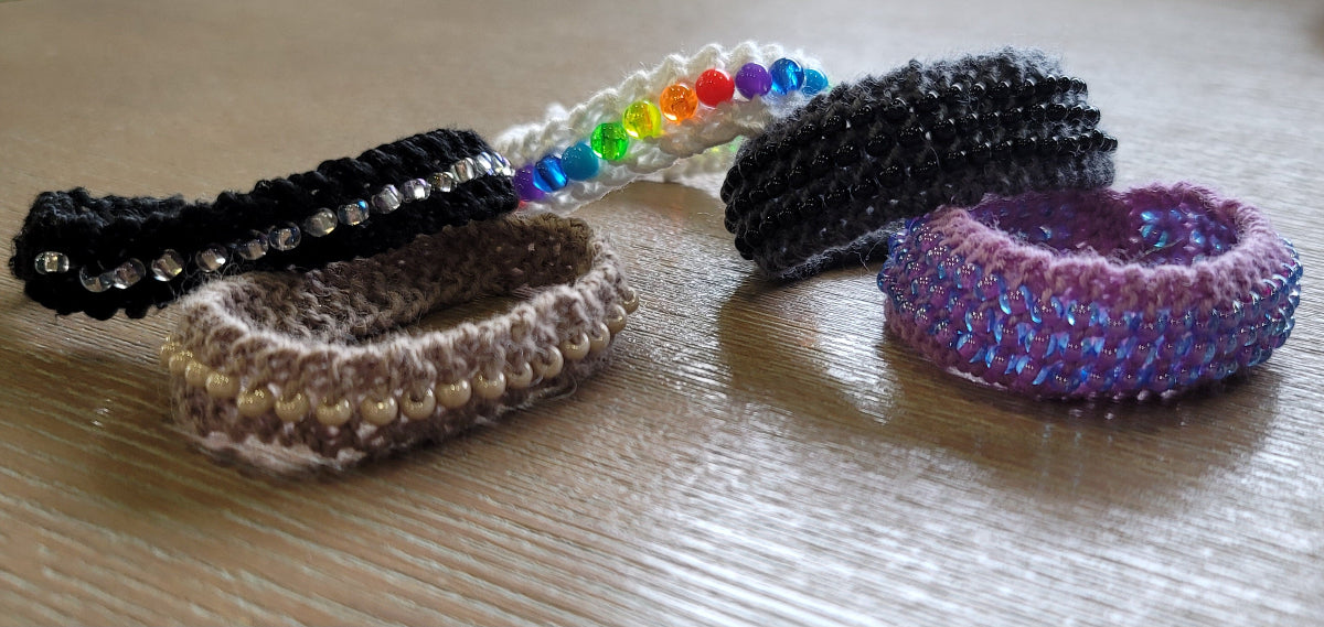Collection of colorful knit, beaded bracelets on a wooden surface