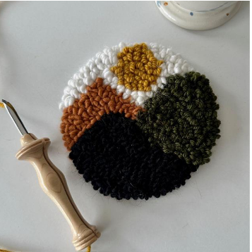 Round woven coaster with colorful patterns on a white surface