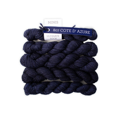 Navy blue yarn skeins with a label on a white background