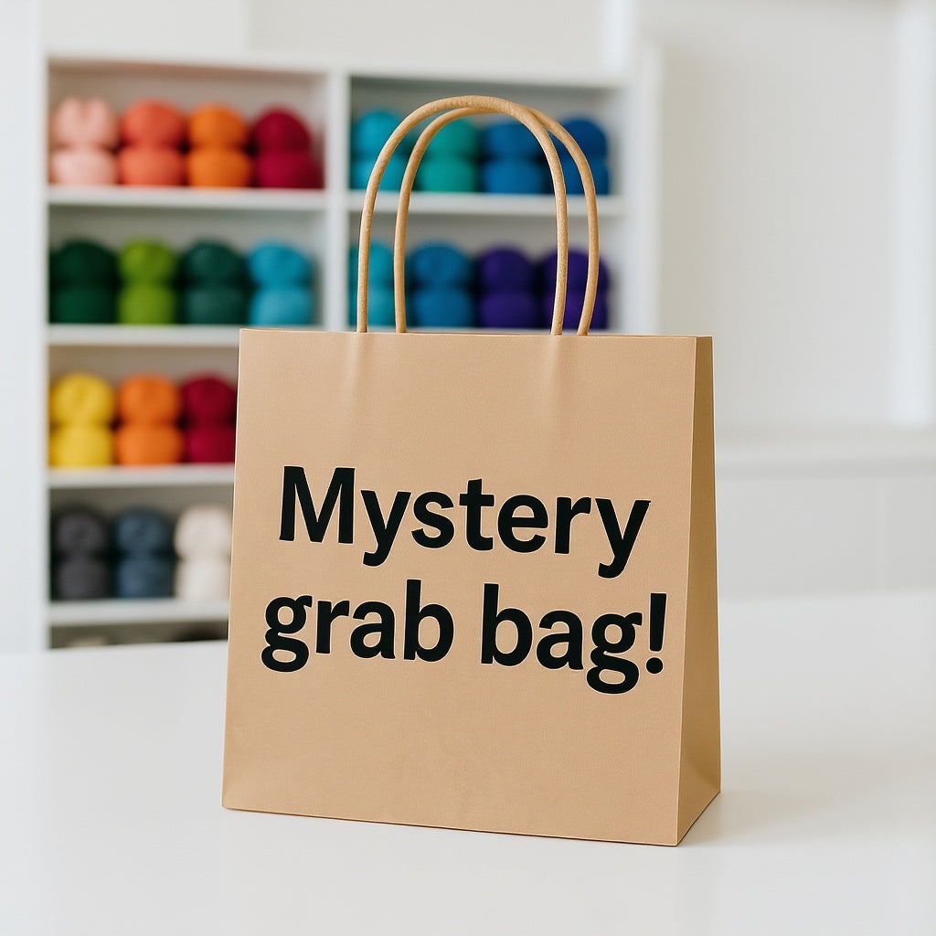 Brown paper bag with 'Mystery grab bag!' text in front of a shelf with colorful items.